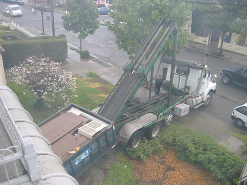 Lifting the dumpster onto the back of the truck