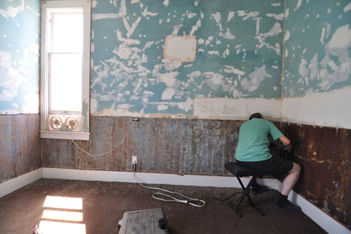 Noel scraping mastic off the bedroom wainscoating