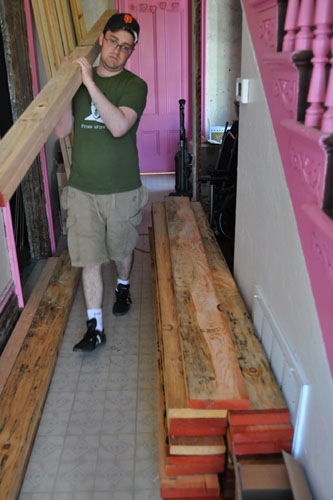 Tim moving a huge pile of lumber into the house
