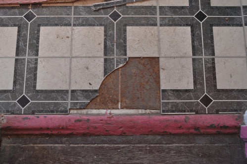 Decomposing particle board under the tiles